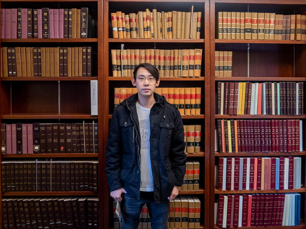 Adam Parkzer standing in front of a shelf of legal books