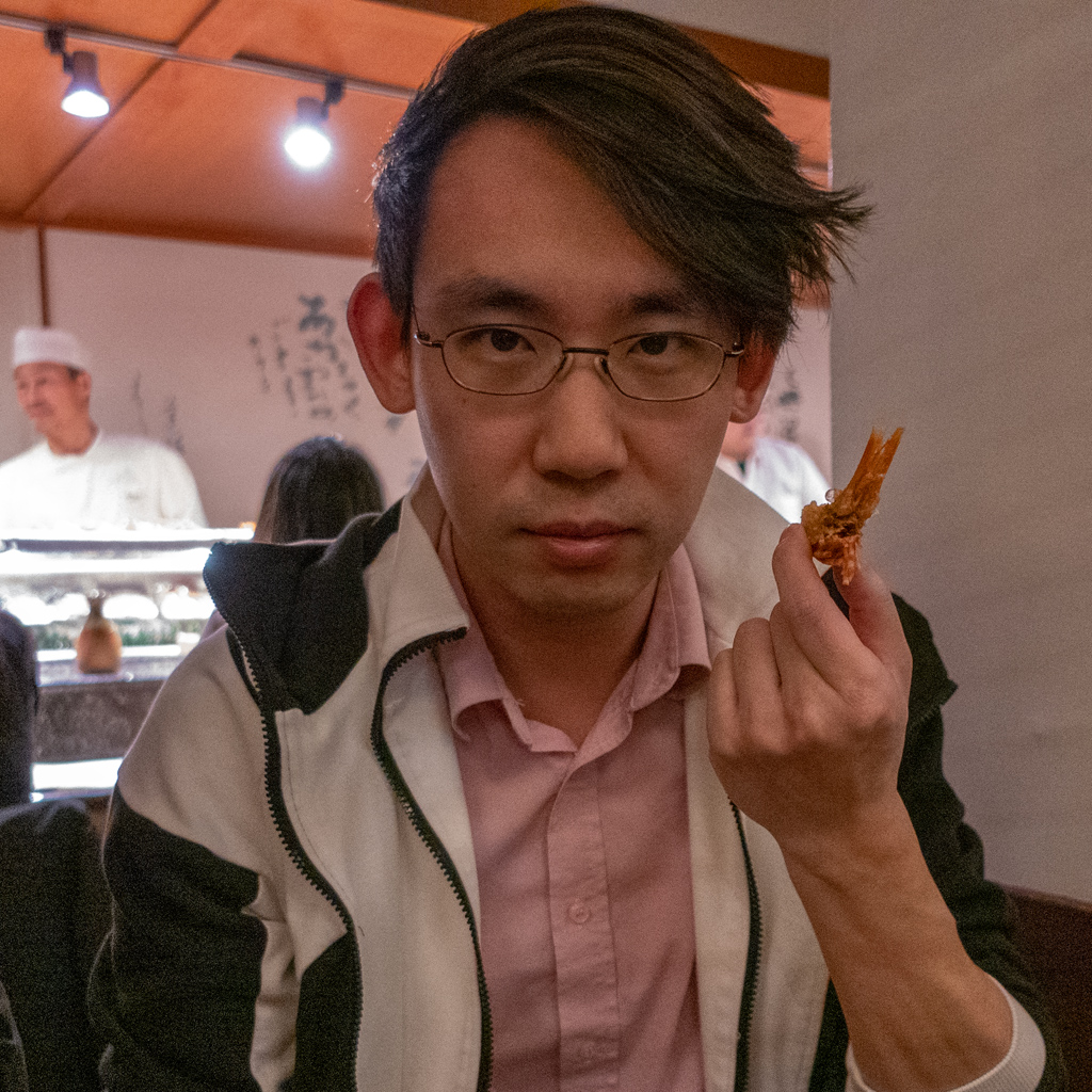 Adam Parkzer holding up a shrimp head next to his own head