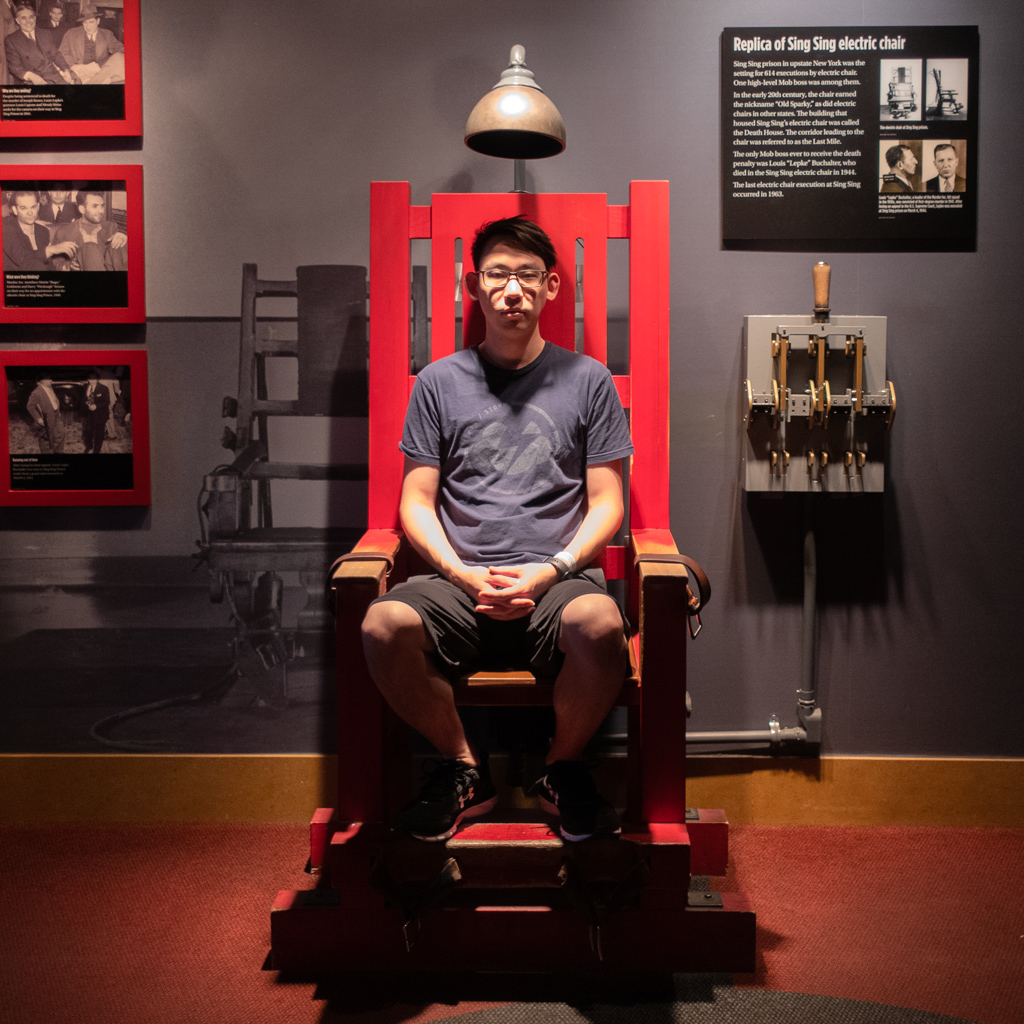 Adam Parkzer sitting in a replica electric chair